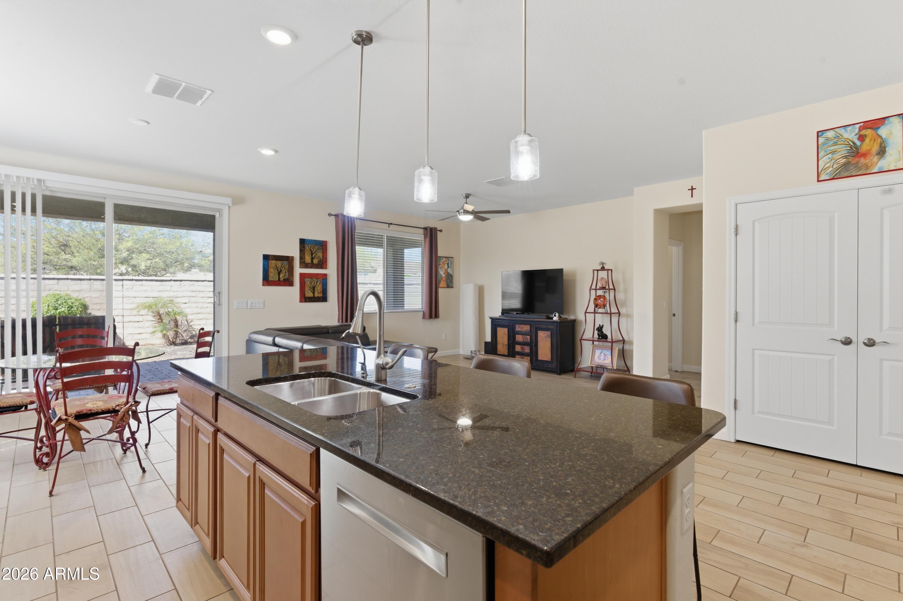 4654 North 204th Lane Buckeye, AZ 85396 - Photo 17 of 41 a kitchen with granite countertop a sink a counter top space appliances and cabinets