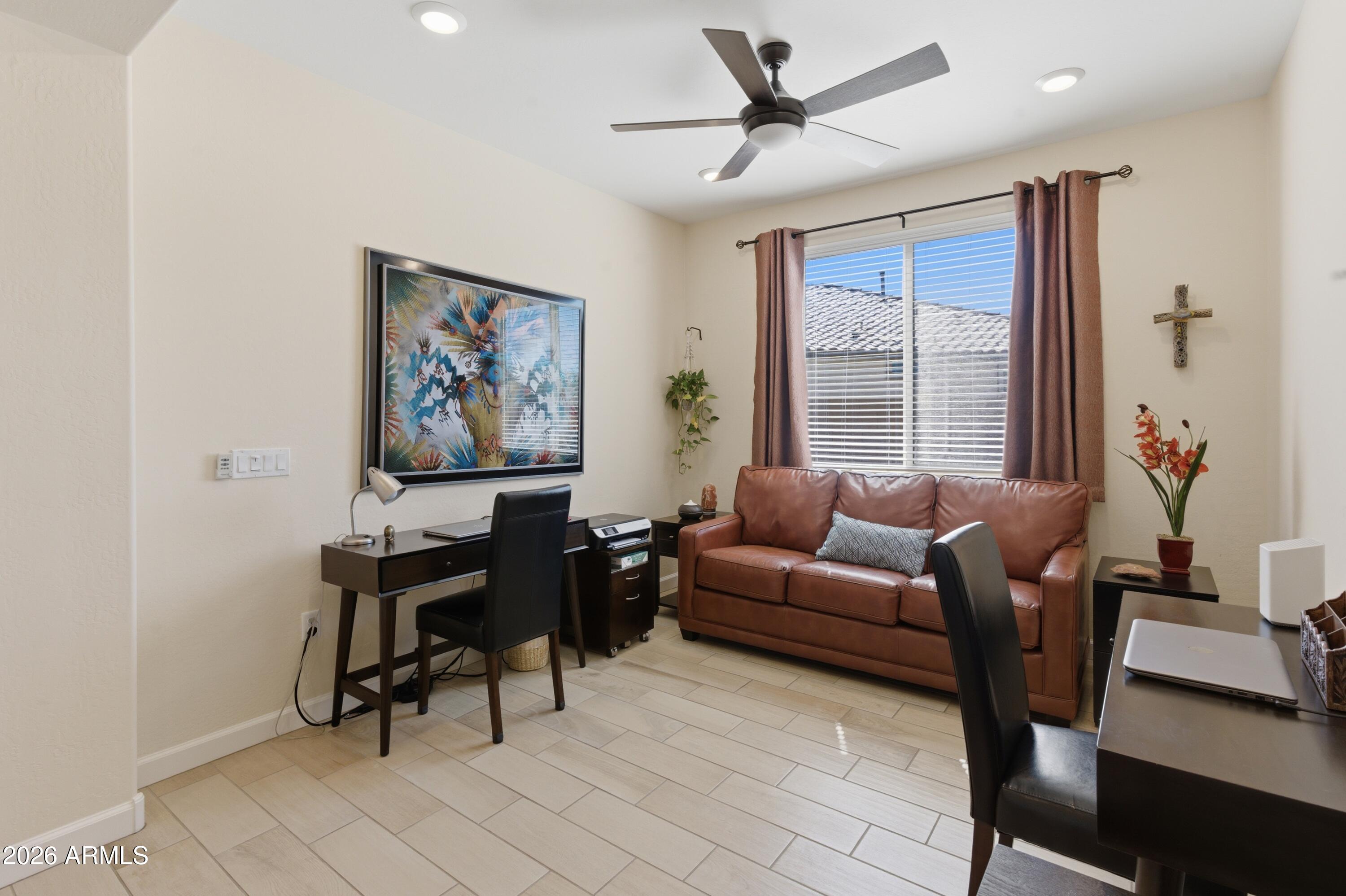 4654 North 204th Lane Buckeye, AZ 85396 - Photo 9 of 41 a living room with furniture a ceiling fan and a window