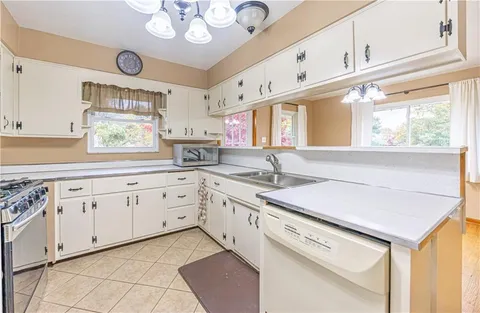 a kitchen with granite countertop cabinets a sink a window and stainless steel appliances