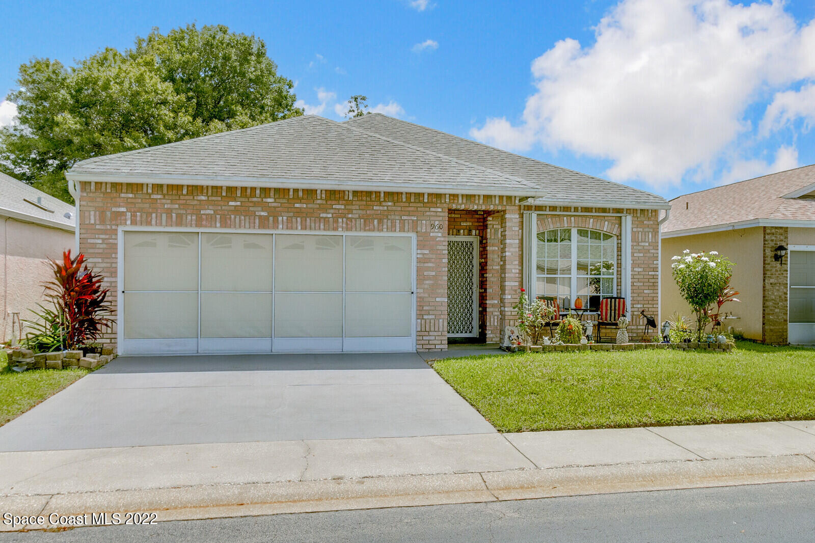 a front view of a house with a garden and garage