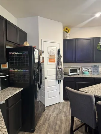 a kitchen with a refrigerator and a stove top oven