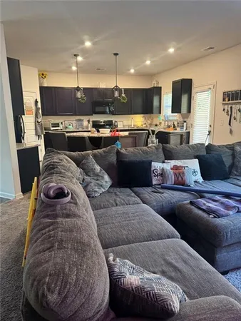 a living room with furniture and a view of kitchen