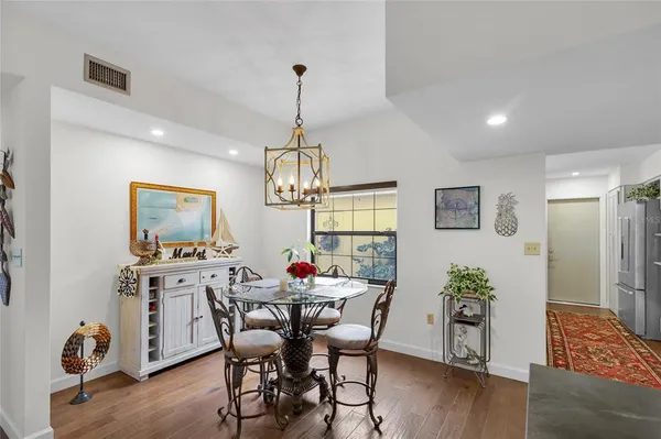 a kitchen with stainless steel appliances kitchen island granite countertop a table and chairs in it
