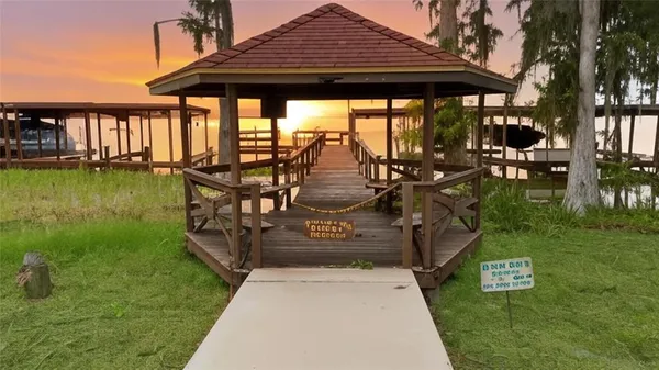 a view of swimming pool with a table and chairs under an umbrella