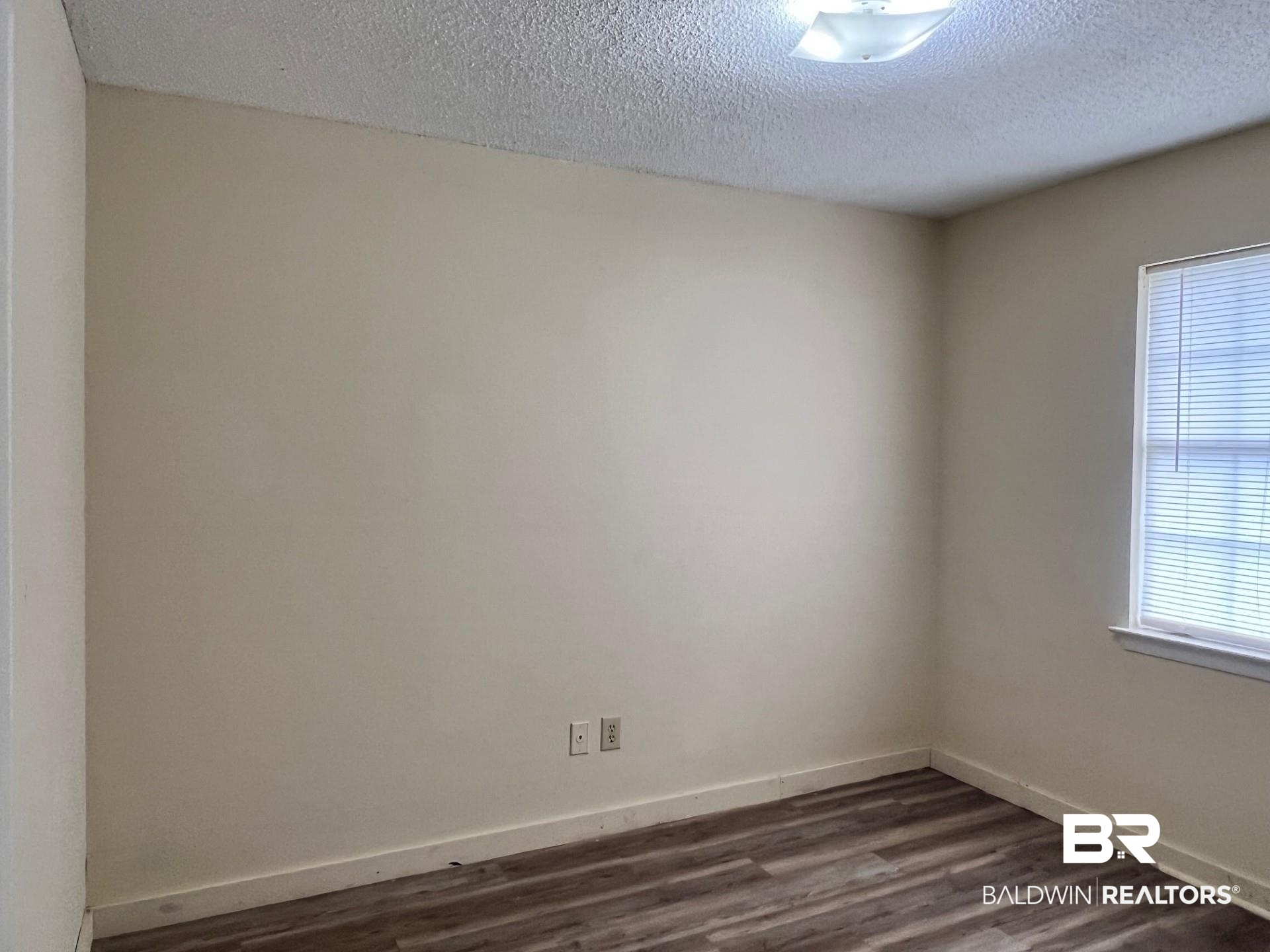 72 Grimes Lane Loxley, AL 36551 - Photo 4 of 12 Unfurnished room featuring dark wood-type flooring and a textured ceiling