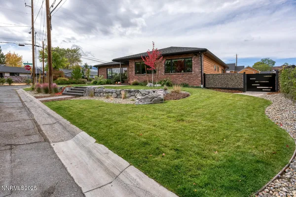 a front view of a house with a garden and fountain