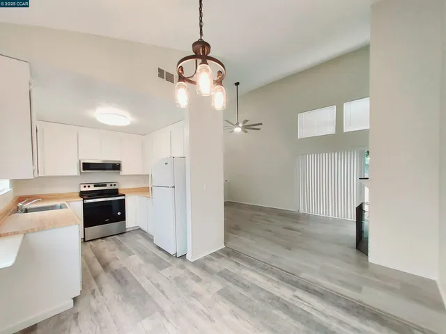 a kitchen with kitchen island stainless steel appliances a stove a refrigerator and a stove top oven