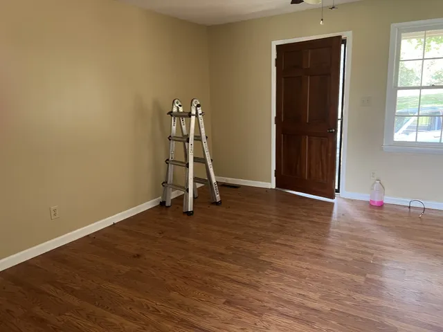 a view of a room with wooden floor and a window
