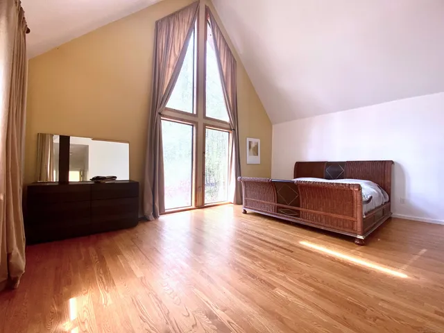 a living room with a bed furniture and a large window