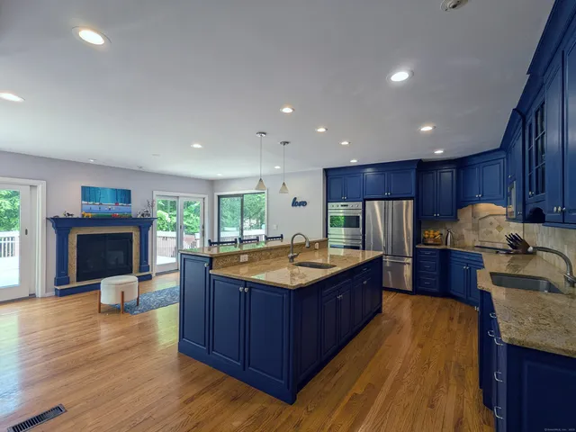 a kitchen with kitchen island granite countertop a sink stove and refrigerator