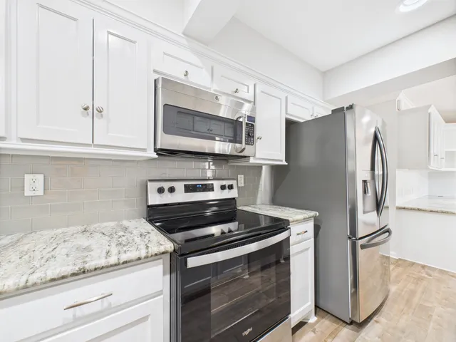 a kitchen with granite countertop cabinets and steel stainless steel appliances