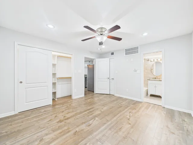 a view of empty room with wooden floor and window