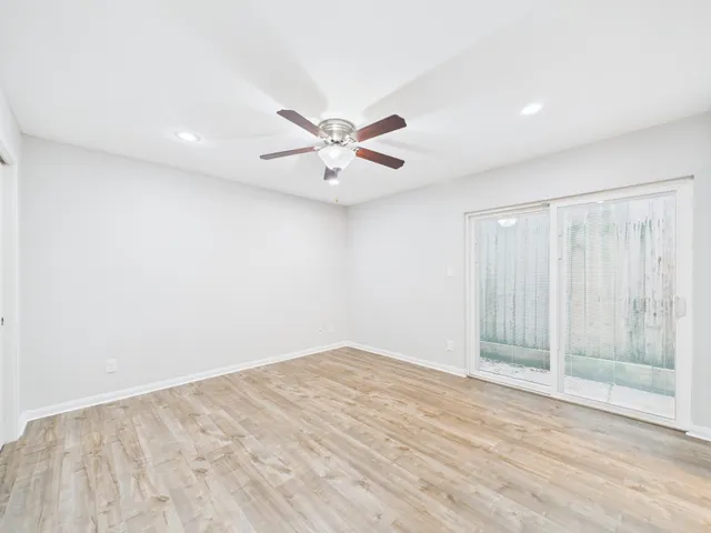 a view of an empty room with a ceiling fan