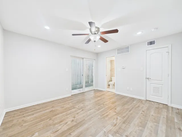 a view of a big room with wooden floor and windows in a room