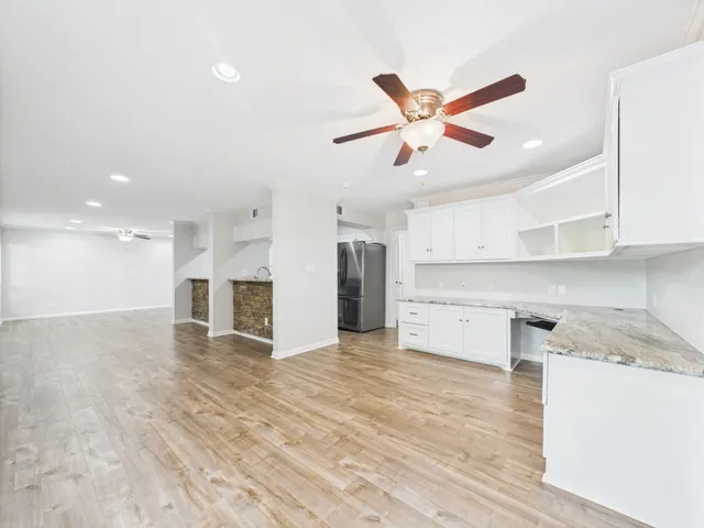 a view of a kitchen with wooden floor and a ceiling fan