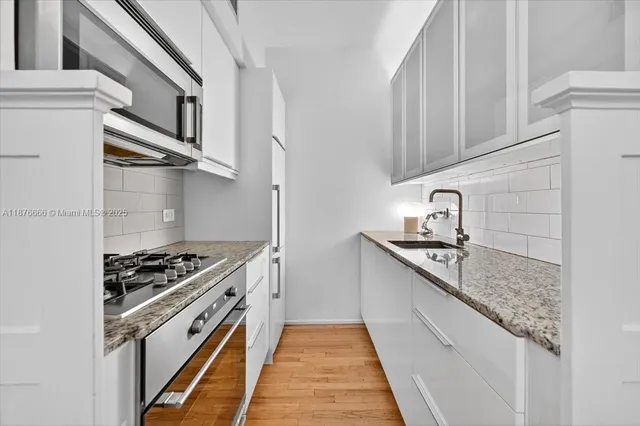 a kitchen with stainless steel appliances granite countertop a sink and cabinets
