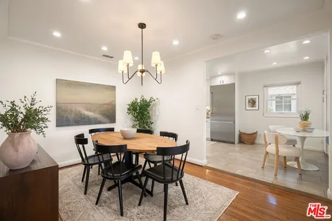a dining room with furniture a chandelier and wooden floor