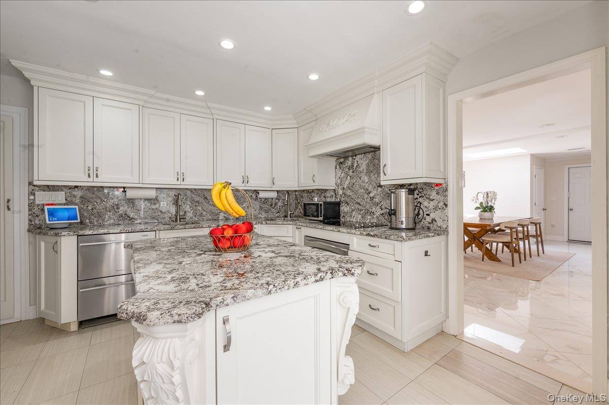 70 Longfellow Road Great Neck, NY 11023 - Photo 10 of 28 a kitchen with white cabinets sink and stove