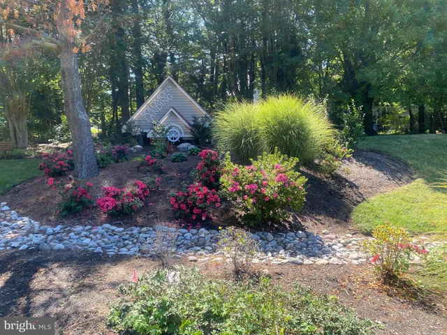 a front view of a house with a yard and fountain in middle