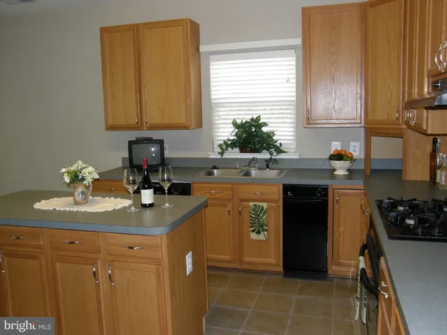 a kitchen with a sink a stove cabinets and a window