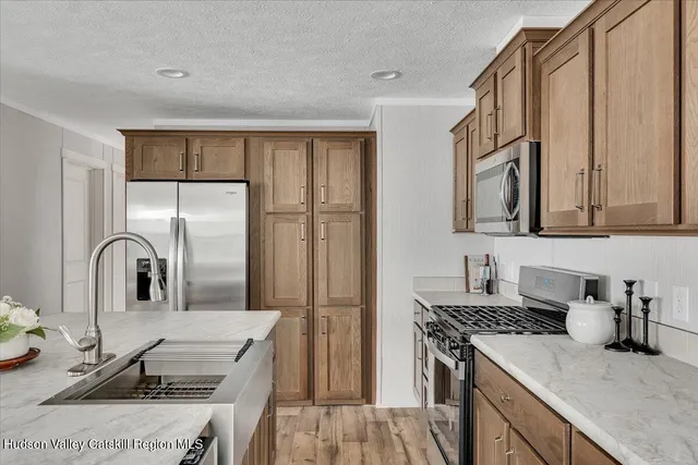 a kitchen with stainless steel appliances granite countertop a sink stove and refrigerator
