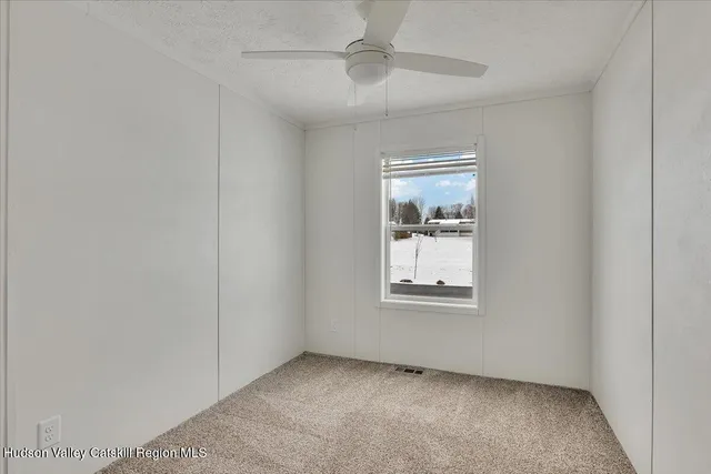 an empty room with a window and wooden floor
