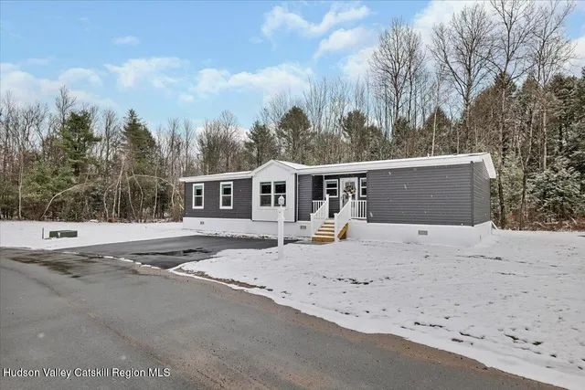 a view of a house with a yard covered in snow