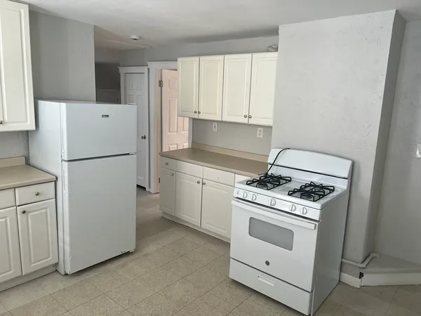 a white refrigerator stove and white cabinets