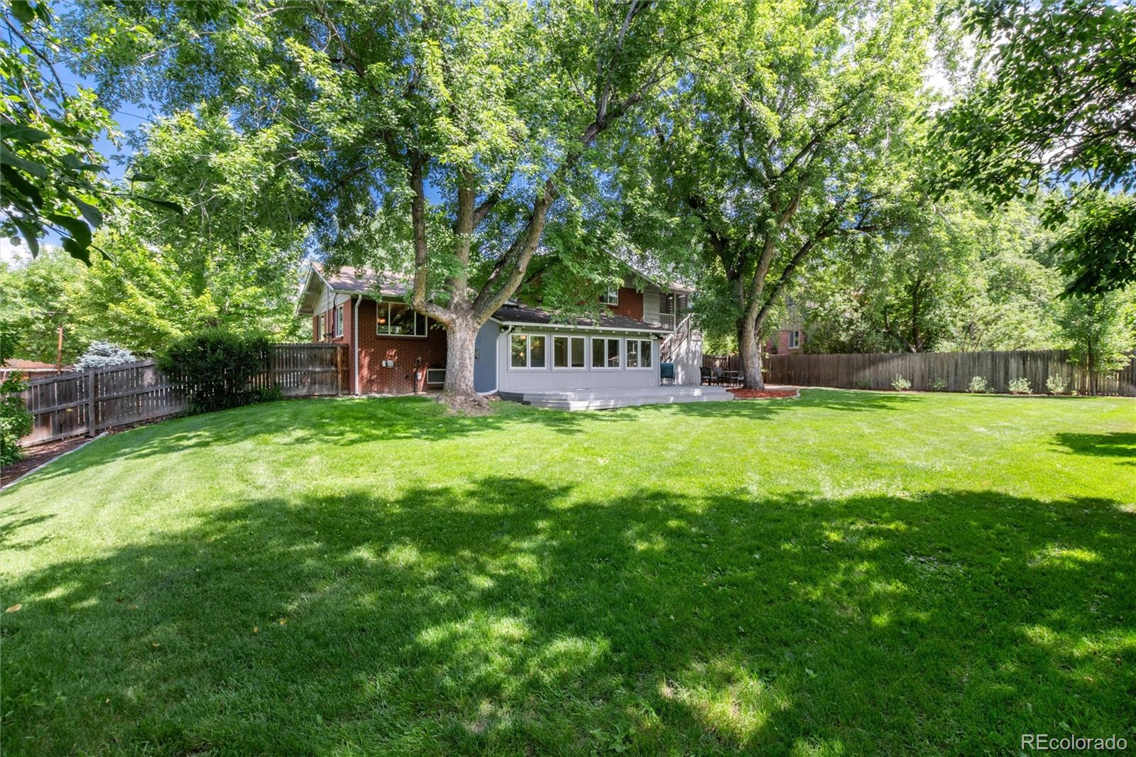 3375 Nelson Street Wheat Ridge, CO 80033 - Photo 31 of 35 a view of a house with a big yard and large trees
