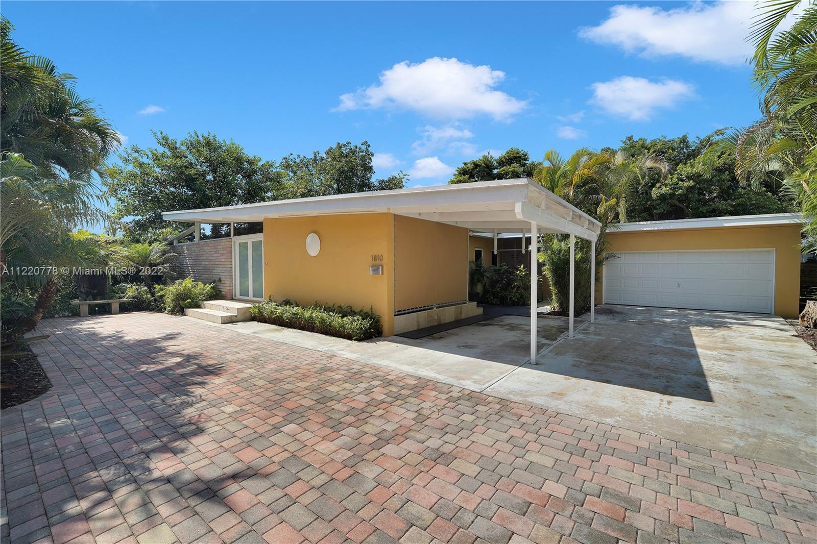 1810 Alamanda Drive North Miami, FL 33181 - Photo 1 of 40 a front view of a house with a yard and garage