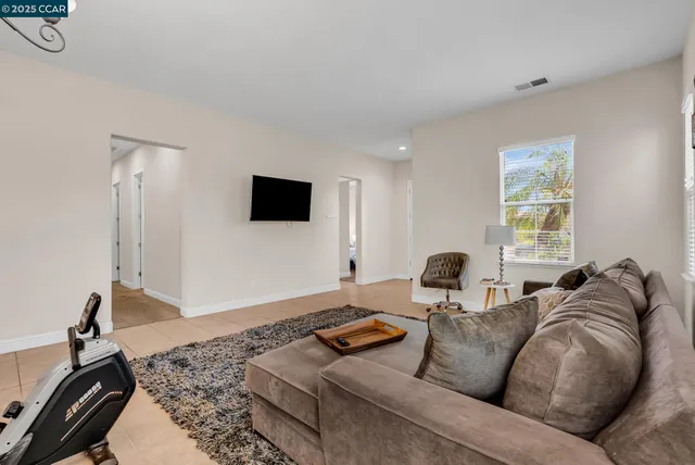 a living room with stainless steel appliances kitchen island granite countertop furniture and a large window