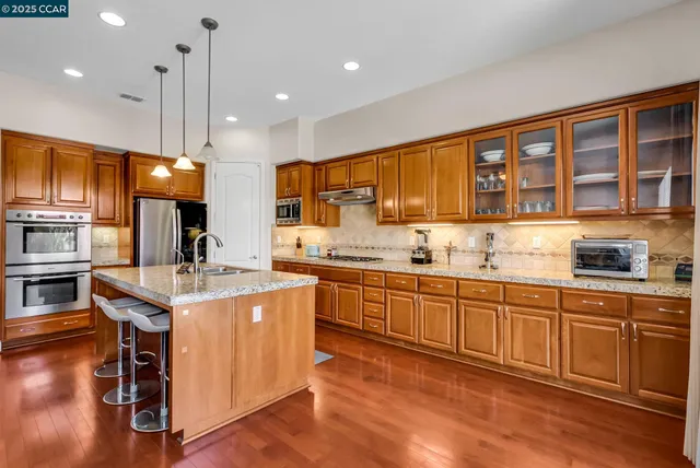 a kitchen with stainless steel appliances granite countertop a stove and a refrigerator