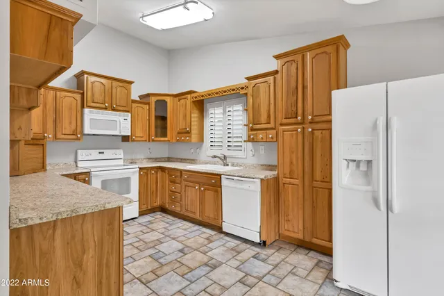 a kitchen with stainless steel appliances granite countertop a refrigerator and a sink