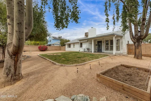 a view of a white house with a yard and potted plants