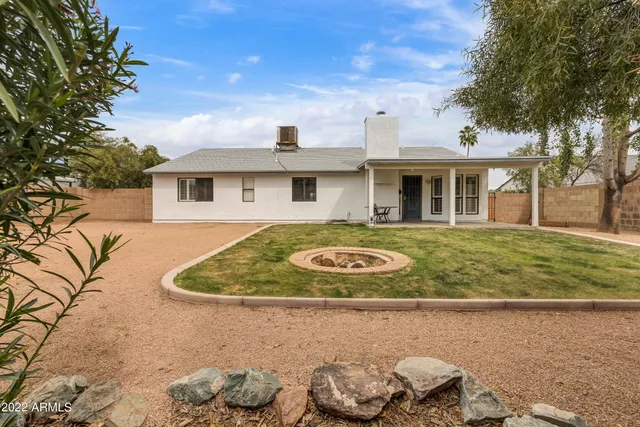 a view of a house with a big yard and potted plants