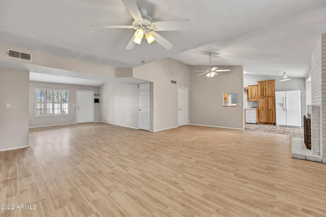 a view of an empty room with window and wooden floor