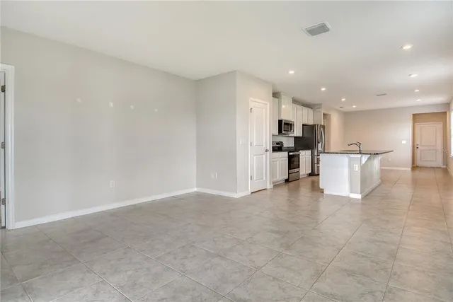 a view of kitchen with kitchen island white cabinets and stainless steel appliances