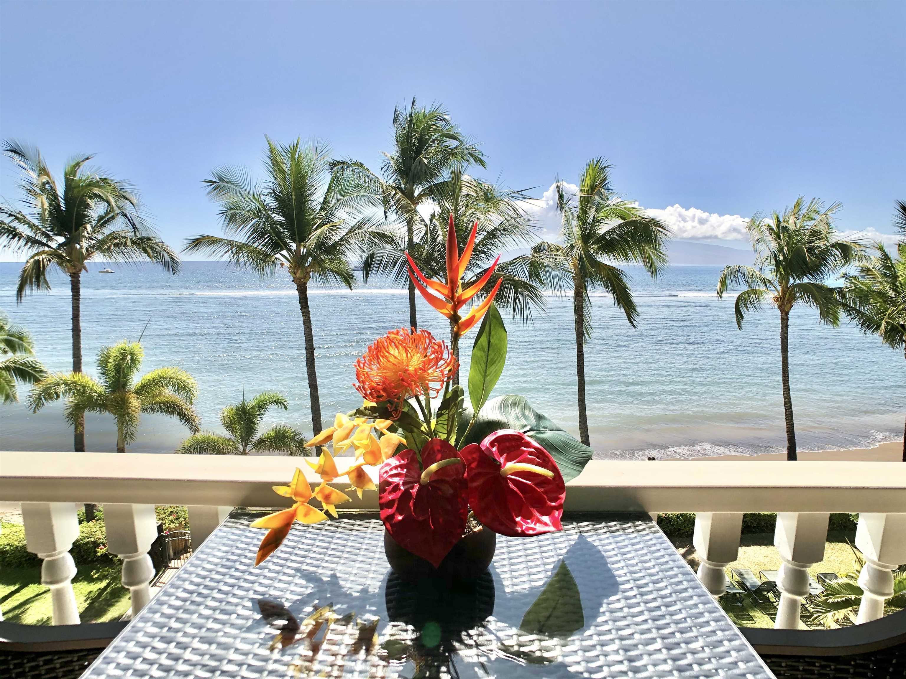 a vase of flowers sitting on a table with a potted plant