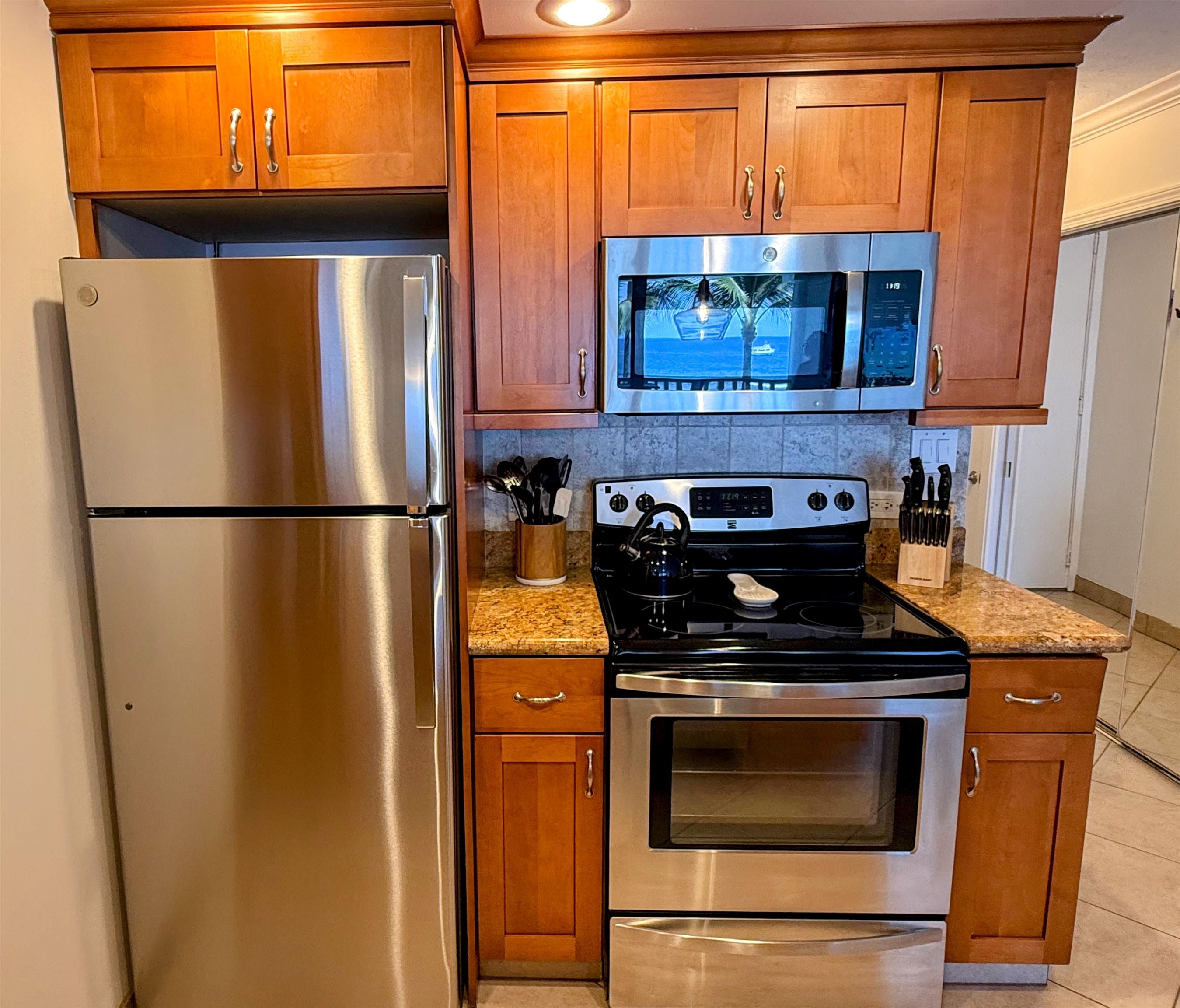 475 Front Street, Unit 419 Lahaina, HI 96761 - Photo 14 of 27 a kitchen with stainless steel appliances granite countertop a stove a refrigerator and a microwave oven