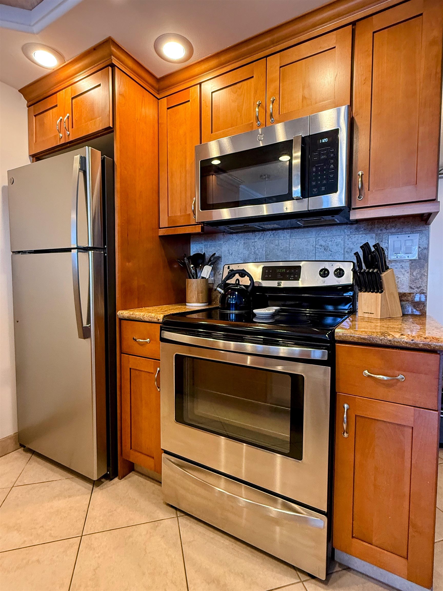 475 Front Street, Unit 419 Lahaina, HI 96761 - Photo 19 of 27 a kitchen with stainless steel appliances granite countertop a stove microwave and refrigerator