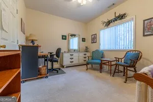 a living room with furniture a computer on desk and a window