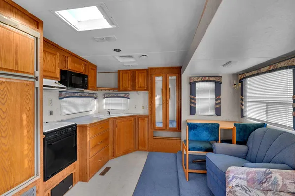 a view of living room kitchen with stainless steel appliances granite countertop lots of counter top space