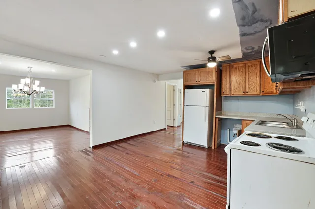 a kitchen with stainless steel appliances granite countertop a sink dishwasher stove top oven and cabinets with wooden floor