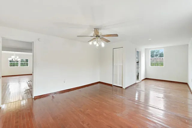 an empty room with wooden floor and mirror