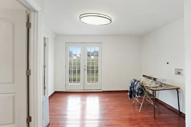 a view of a room with wooden floor lounge chair and windows