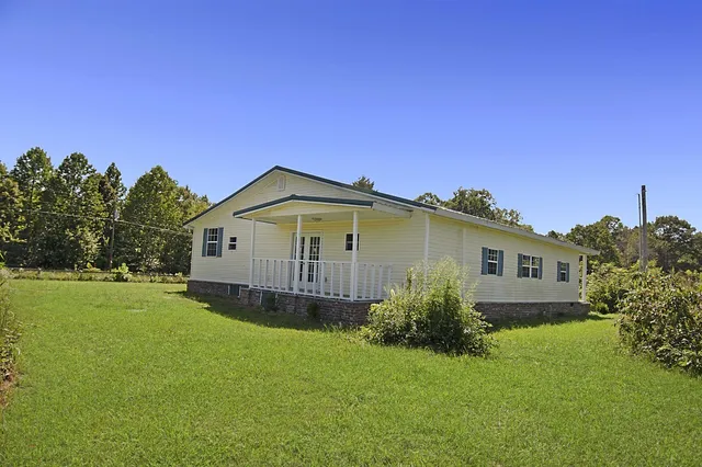 a view of a large garden with a house in the background