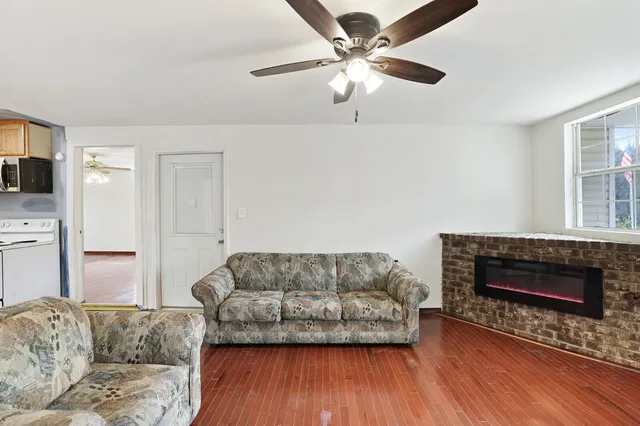 a living room with furniture a flat screen tv and a fireplace