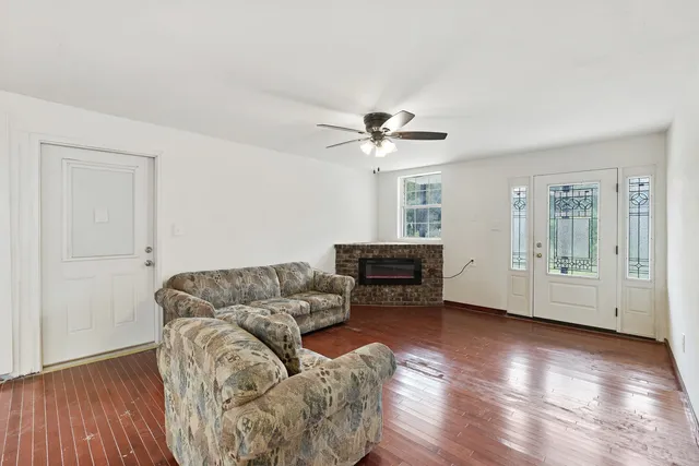 a living room with furniture and a wooden floor