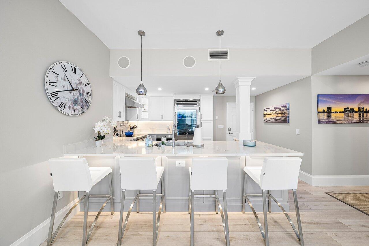255 Evernia Street, Unit 1502 West Palm Beach, FL 33401 - Photo 13 of 40 a kitchen with a dining table and chairs