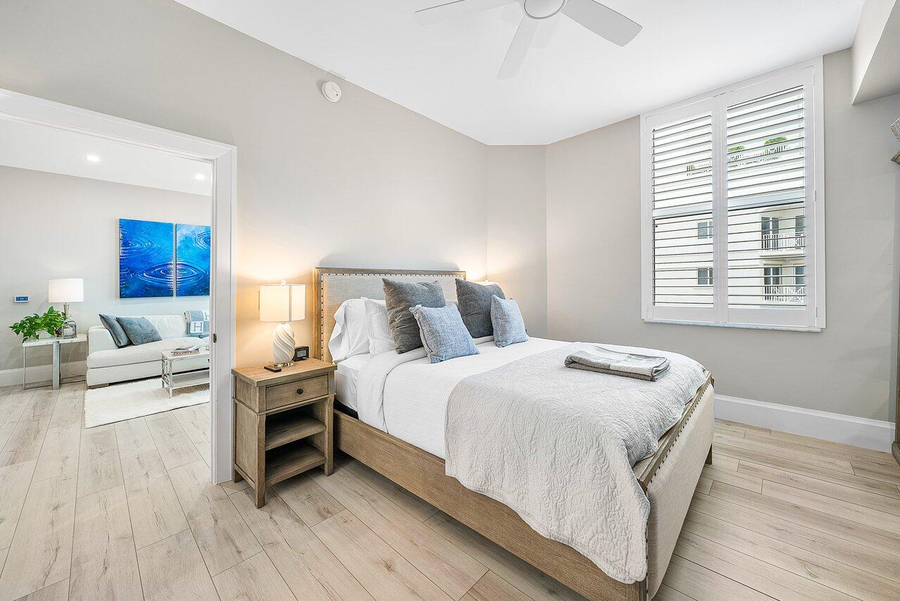 255 Evernia Street, Unit 1502 West Palm Beach, FL 33401 - Photo 15 of 40 a spacious bedroom with a bed and a wooden floor